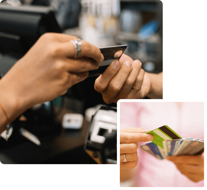 A person holding their credit card while using a cell phone.